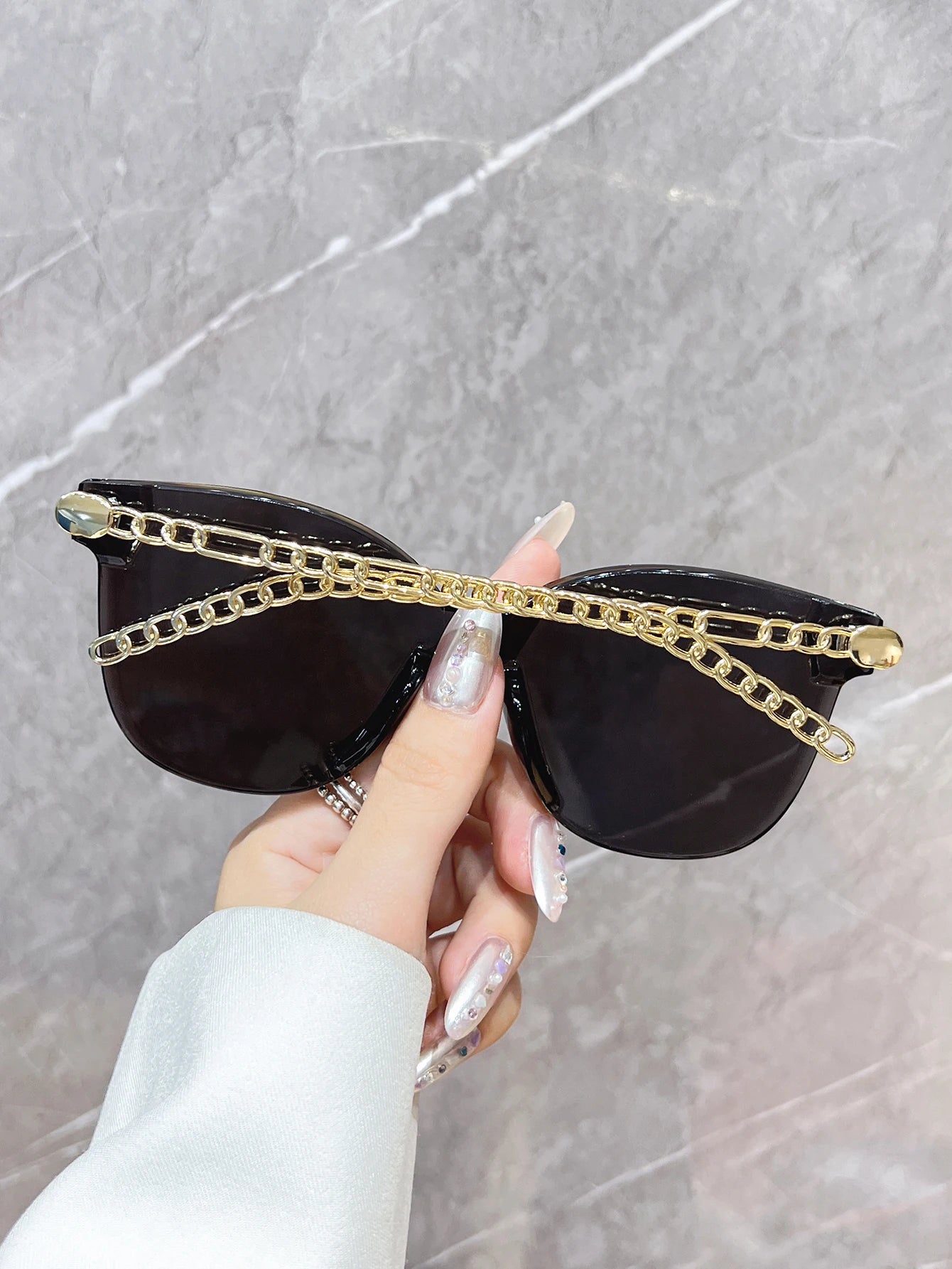 A stylish, frameless, oversized, square-shaped fashion sunglasses with unique chain-style armbands. Perfect for wearing at beach